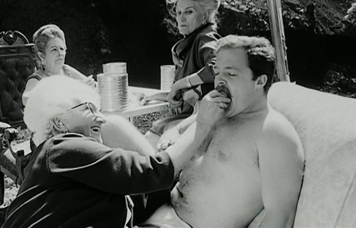 Kadrs no filmas "Fando un Lisa / Fando y Lis" (1968). Meksikas publiku šokēja "sirmās māmuļas" arhetipa vulgārā reprezentācija – filmā tās atveidotas kā seksuālas būtnes, kuras spēlē azartspēles un ar sulīgiem persikiem erotiskā manierē baro blakus zvilnošo vīrieti-trofeju.