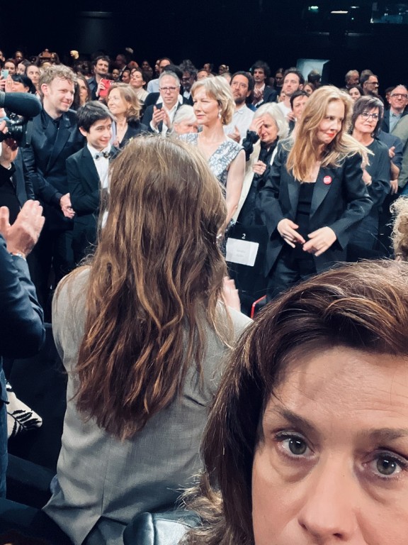 Otrajā plānā centrā - Sandra Hillere un Žistīne Triē pēc filmas "Kritiena anatomija" pirmizrādes Kannu festivālā. Telefona foto: Dita Rietuma